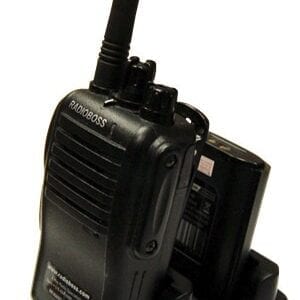 A black walkie talkie is sitting on the ground.