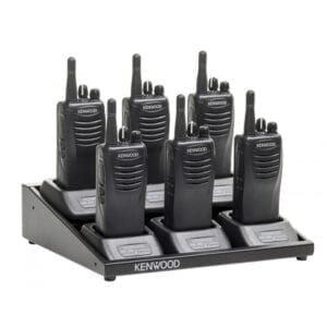 A six pack of walkie talkies on top of a holder.