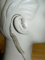 A white ear piece with a telephone cord attached to it.