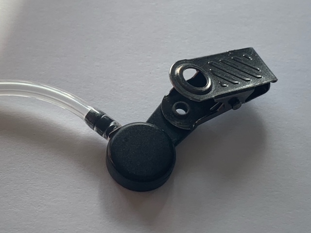 A black clip with a white cord attached to it.
